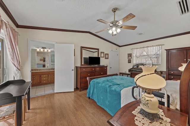 bedroom with lofted ceiling, ensuite bathroom, ceiling fan, light wood-type flooring, and a textured ceiling