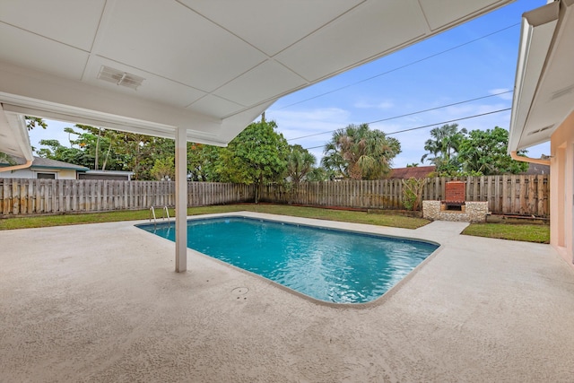 view of swimming pool featuring an outdoor brick fireplace and a patio area