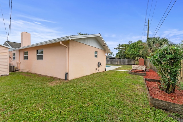 exterior space with central AC and a lawn