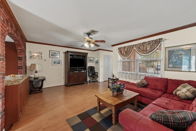 living room featuring ceiling fan, ornamental molding, and hardwood / wood-style flooring