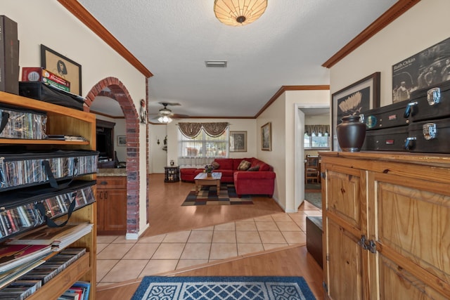 interior space featuring a textured ceiling, ceiling fan, and ornamental molding