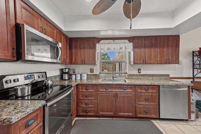 kitchen featuring light stone countertops, appliances with stainless steel finishes, ceiling fan, sink, and light tile patterned floors