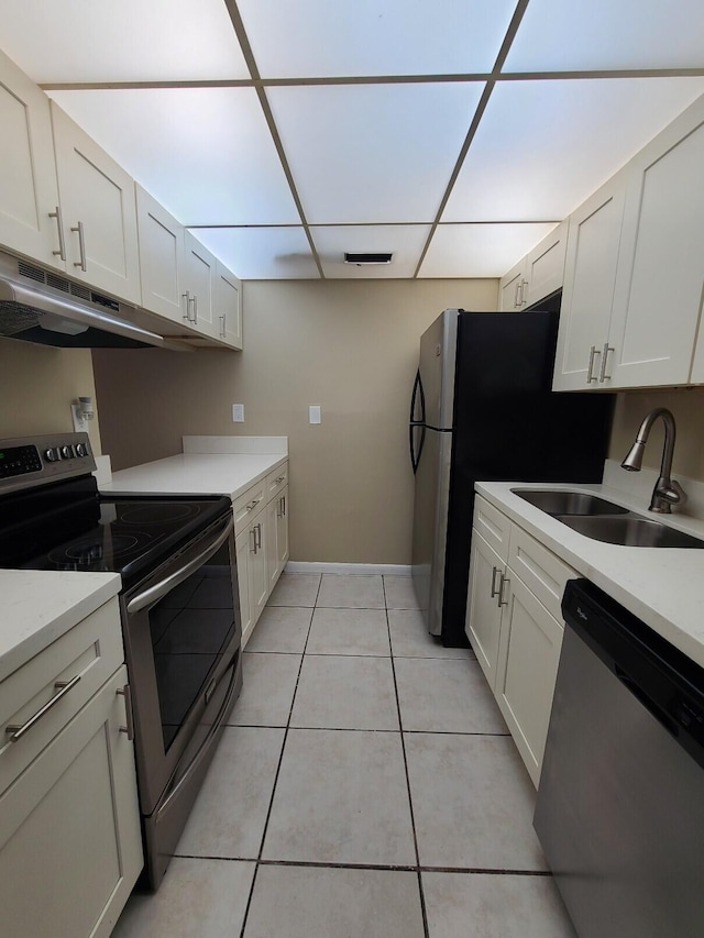 kitchen with sink, white cabinets, light tile patterned floors, and appliances with stainless steel finishes