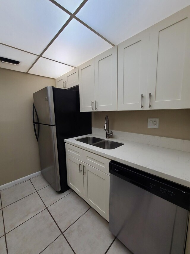 kitchen with white cabinetry, sink, light tile patterned floors, and appliances with stainless steel finishes