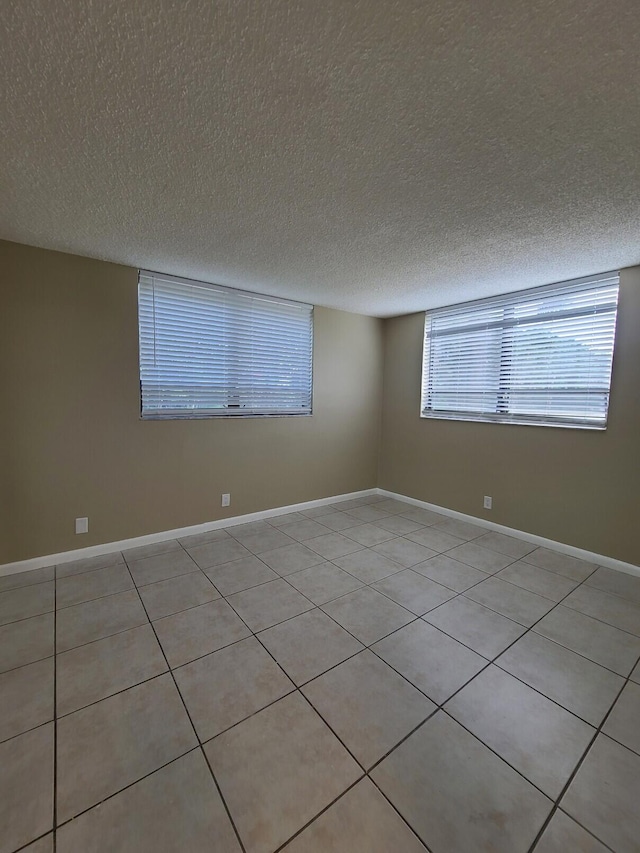 tiled spare room with a textured ceiling