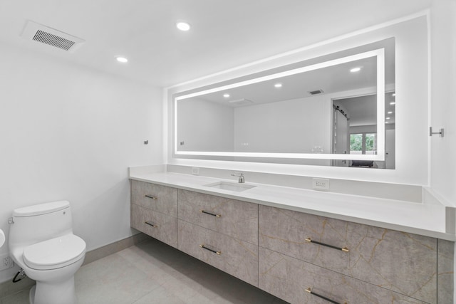 bathroom with tile patterned flooring, vanity, and toilet