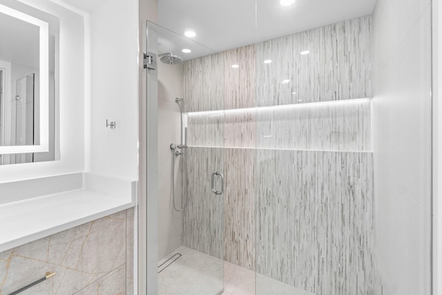 bathroom featuring tiled shower and tile patterned flooring