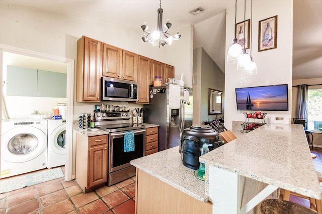 kitchen featuring independent washer and dryer, pendant lighting, lofted ceiling, an inviting chandelier, and appliances with stainless steel finishes