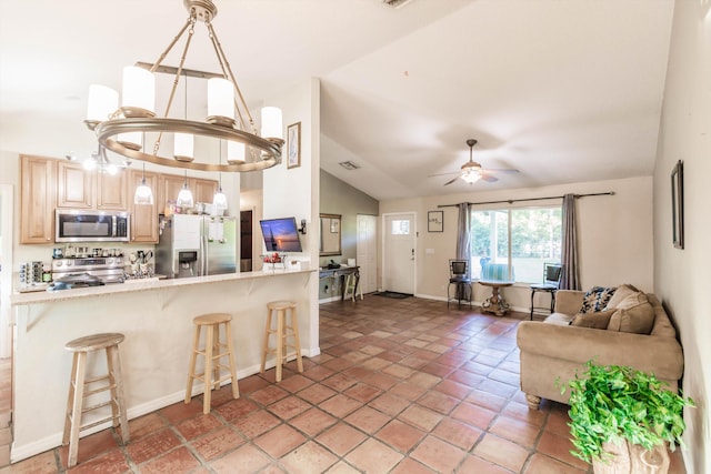 kitchen with stainless steel appliances, lofted ceiling, pendant lighting, and a kitchen breakfast bar