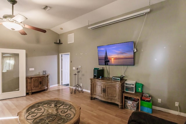 living room with lofted ceiling, ceiling fan, and light hardwood / wood-style flooring