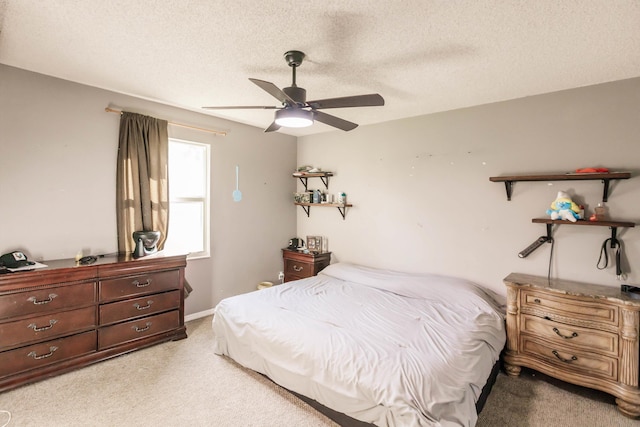 bedroom featuring a textured ceiling, ceiling fan, and light colored carpet