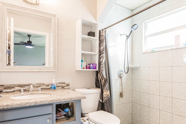 bathroom with toilet, curtained shower, ceiling fan, and vanity