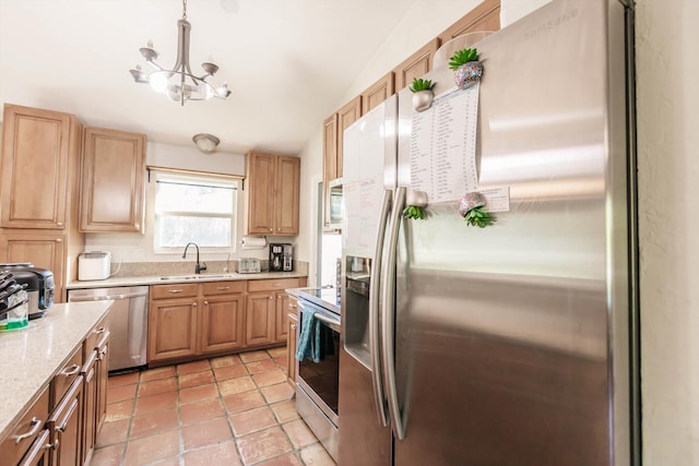 kitchen featuring stainless steel appliances, sink, light tile patterned floors, a chandelier, and pendant lighting