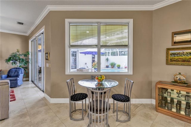 dining room featuring ornamental molding and light tile patterned flooring