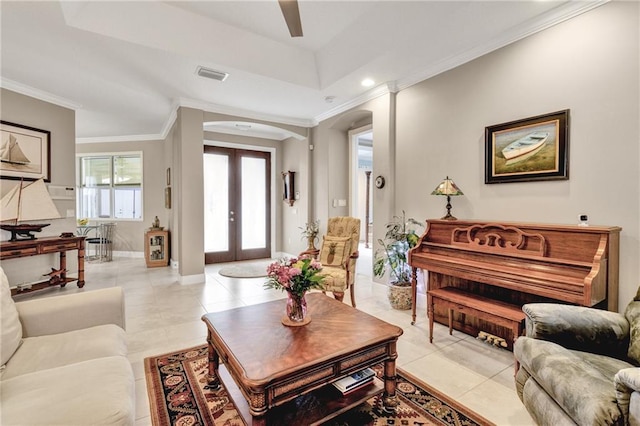 living room with french doors, a tray ceiling, light tile patterned floors, and ornamental molding