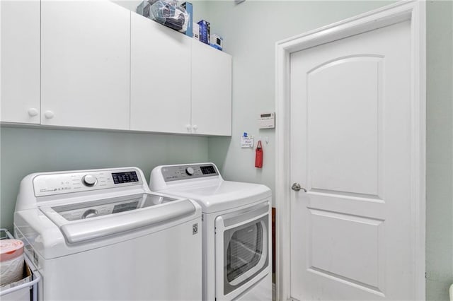 washroom featuring cabinets and independent washer and dryer