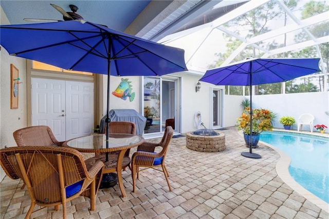 view of patio / terrace with a fenced in pool, a lanai, and an outdoor fire pit