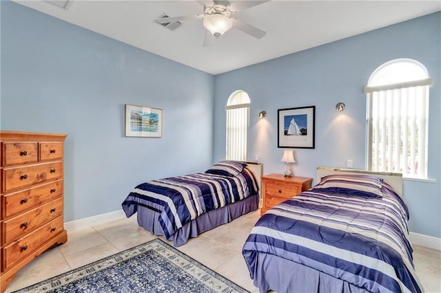 tiled bedroom featuring ceiling fan and multiple windows