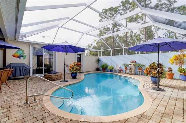 view of pool with glass enclosure and a patio