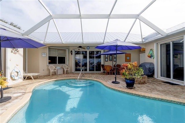 view of swimming pool with area for grilling, a patio, and glass enclosure