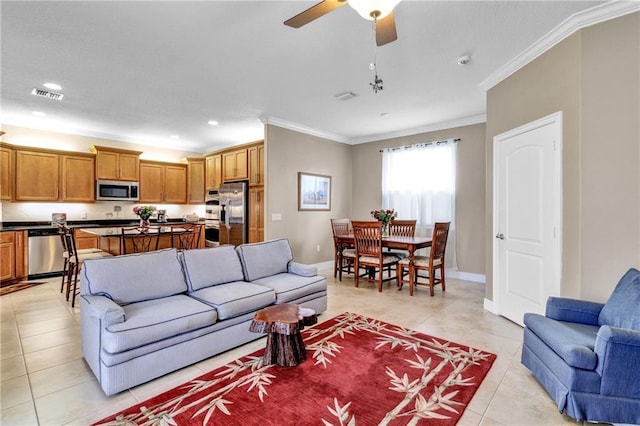 living room with crown molding, light tile patterned floors, and ceiling fan