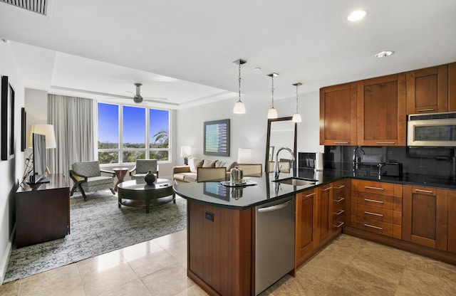 kitchen with decorative light fixtures, tasteful backsplash, sink, kitchen peninsula, and stainless steel appliances