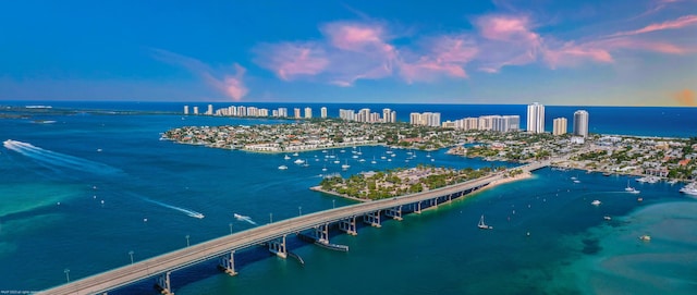 aerial view at dusk featuring a water view