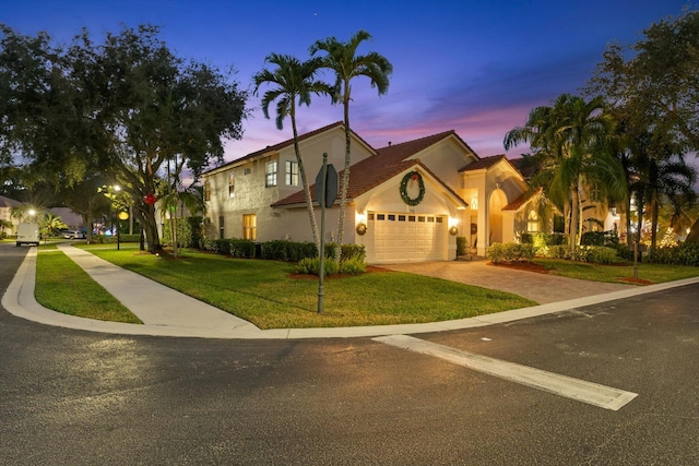 mediterranean / spanish-style house featuring a yard and a garage