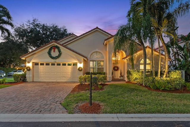 mediterranean / spanish-style home with a yard and a garage