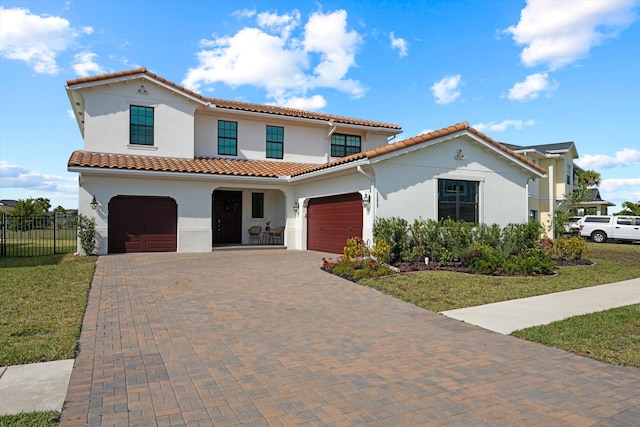 mediterranean / spanish-style house with a garage and a front lawn