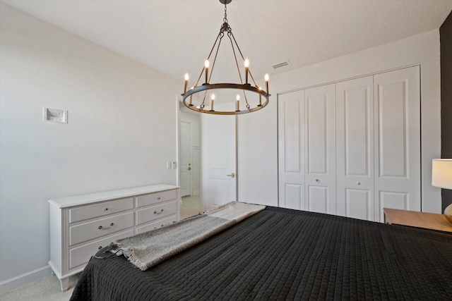 bedroom featuring light carpet, a notable chandelier, and a closet