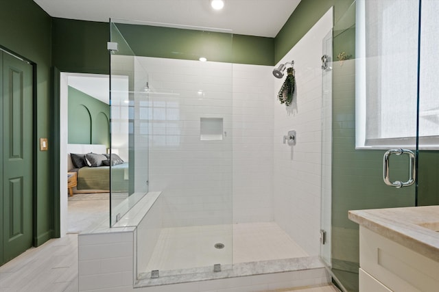 bathroom with a shower with door and vanity