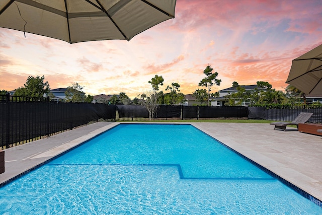 pool at dusk with a patio