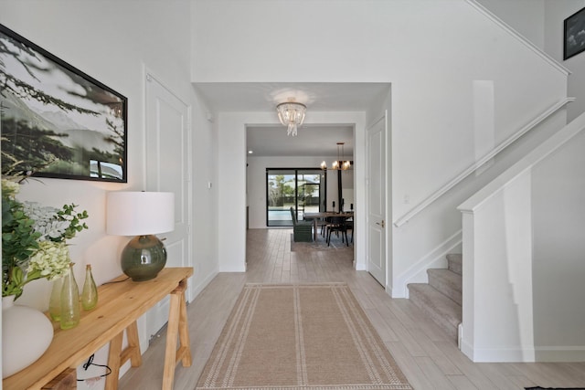 entryway with an inviting chandelier and light wood-type flooring