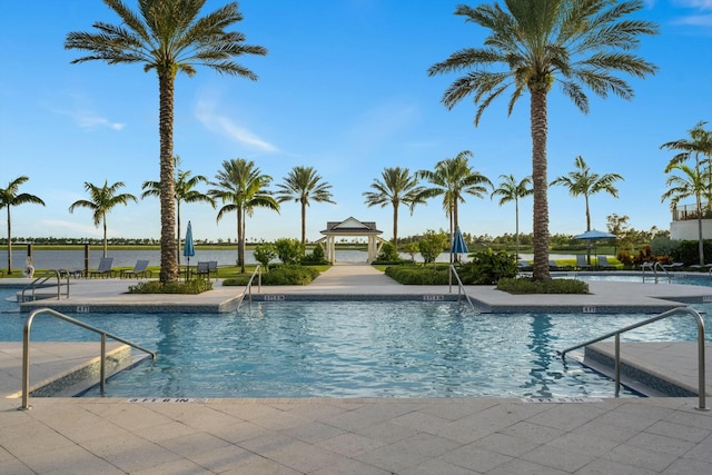 view of pool featuring a gazebo, a water view, and a patio area