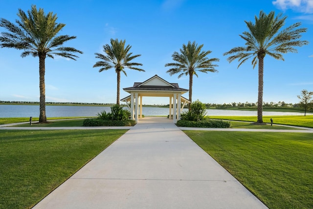 surrounding community with a water view, a gazebo, and a lawn