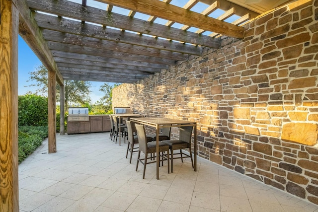 view of patio featuring exterior kitchen and a pergola