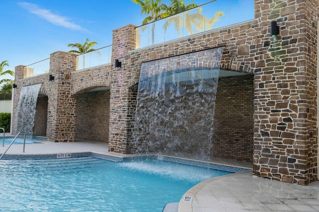 view of swimming pool with pool water feature