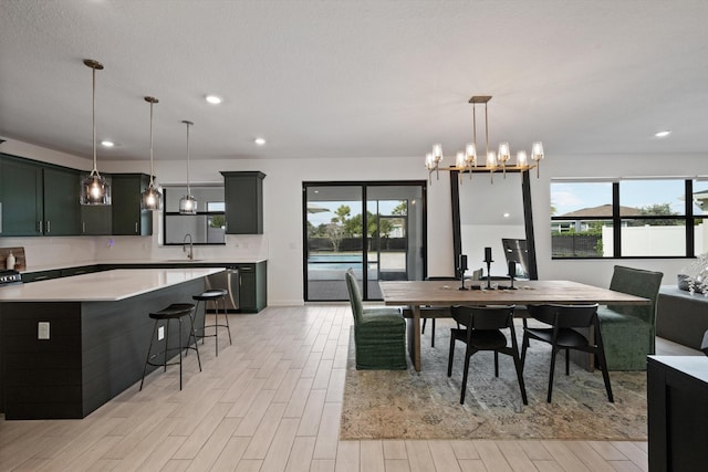 dining space with a notable chandelier, sink, and light wood-type flooring