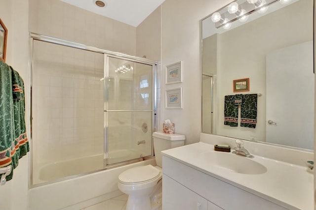 full bathroom featuring tile patterned floors, toilet, vanity, and combined bath / shower with glass door