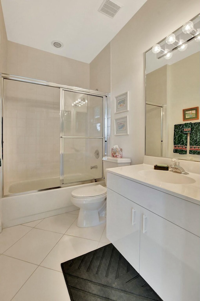 full bathroom with shower / bath combination with glass door, vanity, tile patterned flooring, and toilet