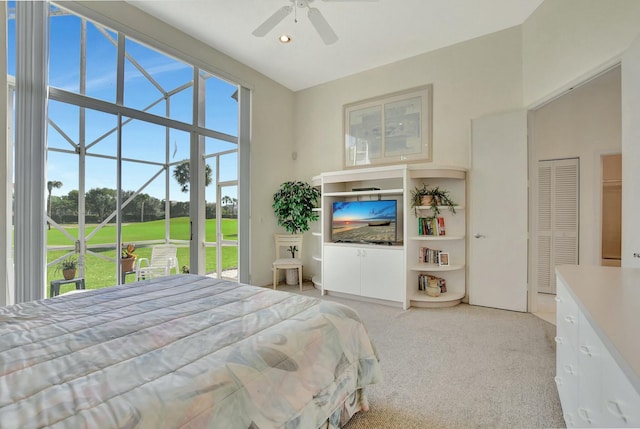 bedroom featuring light colored carpet, a closet, and ceiling fan