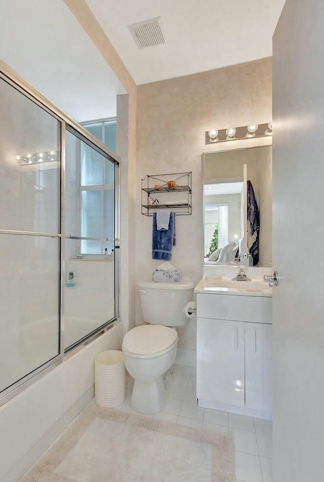 full bathroom featuring tile patterned floors, vanity, toilet, and combined bath / shower with glass door