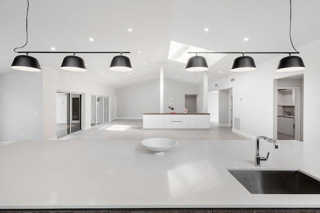 kitchen featuring sink, decorative light fixtures, and lofted ceiling