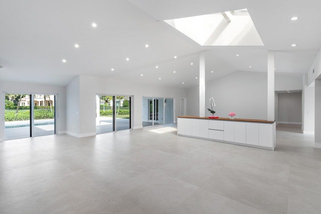 unfurnished living room featuring high vaulted ceiling