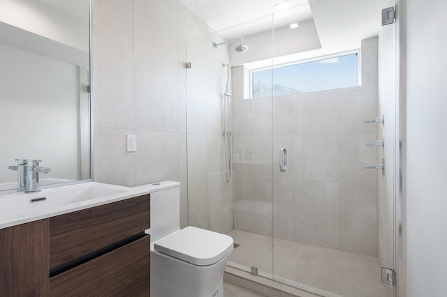 bathroom with tile walls, an enclosed shower, vanity, and toilet