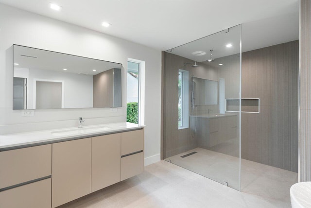 bathroom with a tile shower and vanity