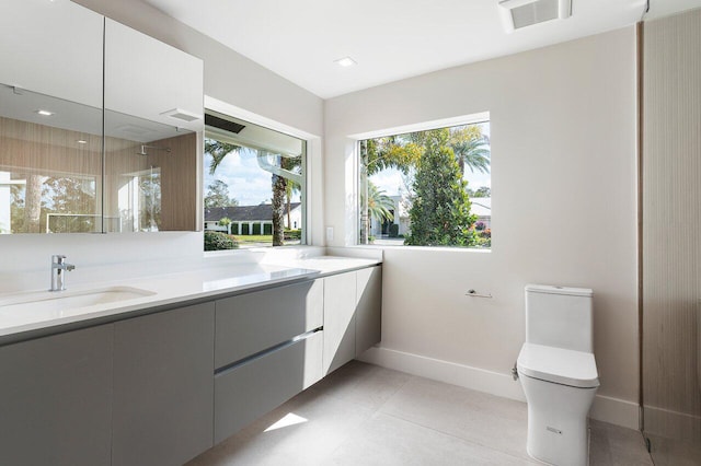 bathroom featuring toilet, tile patterned flooring, and vanity