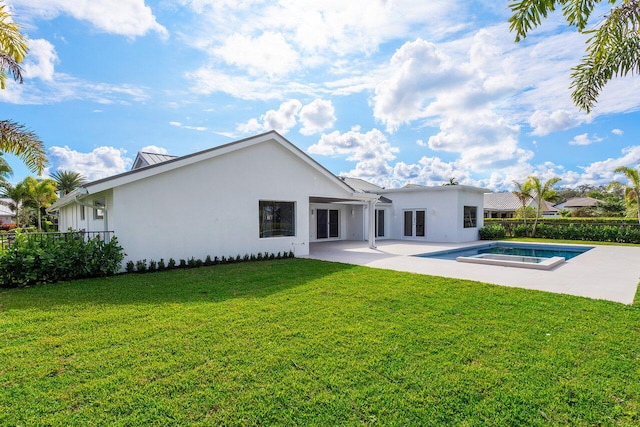 back of house with a lawn, a swimming pool with hot tub, and a patio