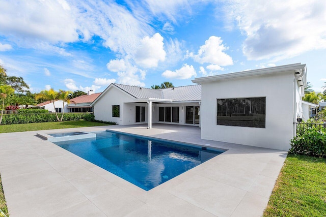 rear view of house with a fenced in pool and a patio